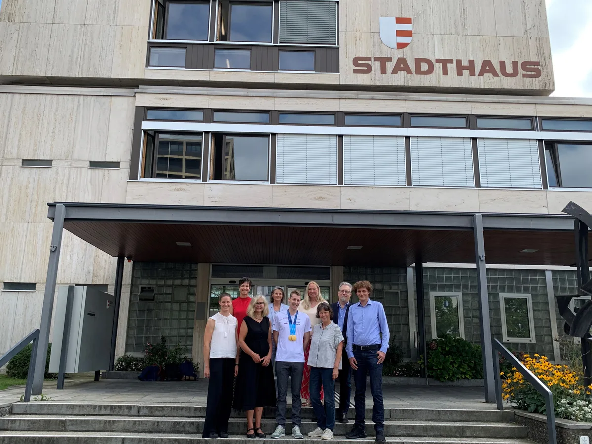 Stadtpräsidentin Thalmann (zweite von links) ehrte Riccardo Rancan (Mitte) zusammen mit weiteren Vertretern des Stadtrats und der Verwaltung. Man sieht eine Gruppe von Menschen vor dem Stadthaus.